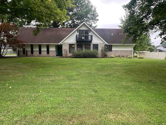 view of front of home with a balcony and a front yard