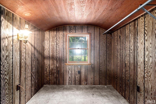 unfurnished room with wooden walls, wooden ceiling, and vaulted ceiling