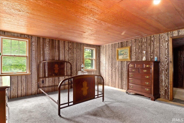 bedroom with wood ceiling, carpet, and wooden walls