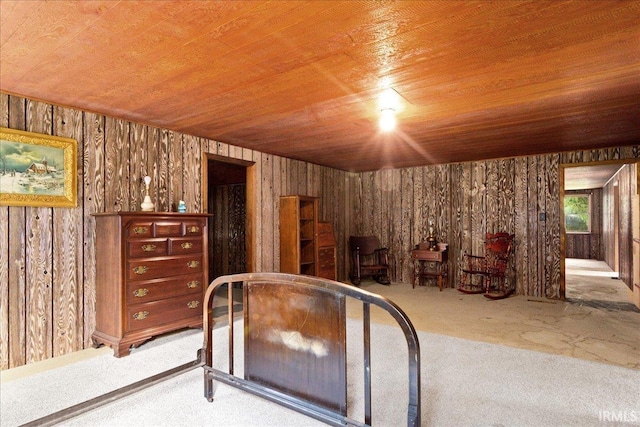 unfurnished bedroom featuring wood ceiling, wood walls, and carpet