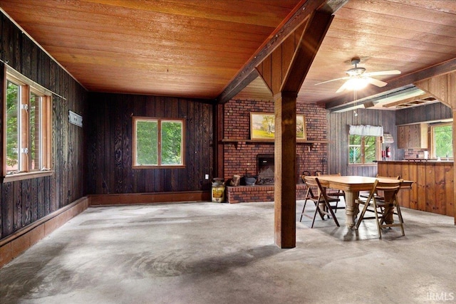 unfurnished dining area with a healthy amount of sunlight, wood ceiling, wooden walls, and ceiling fan