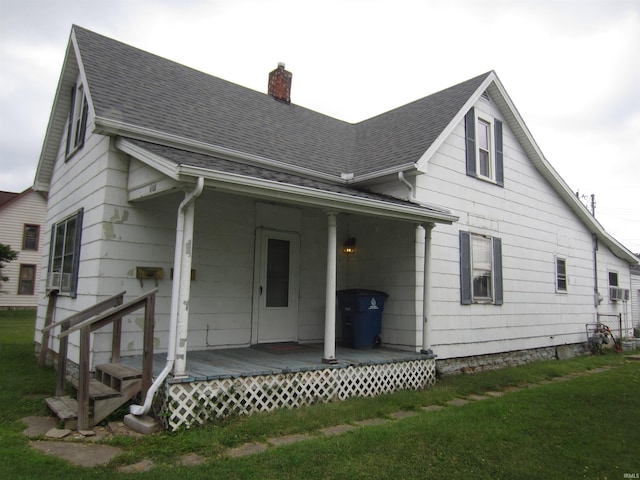 rear view of property with a deck and a lawn