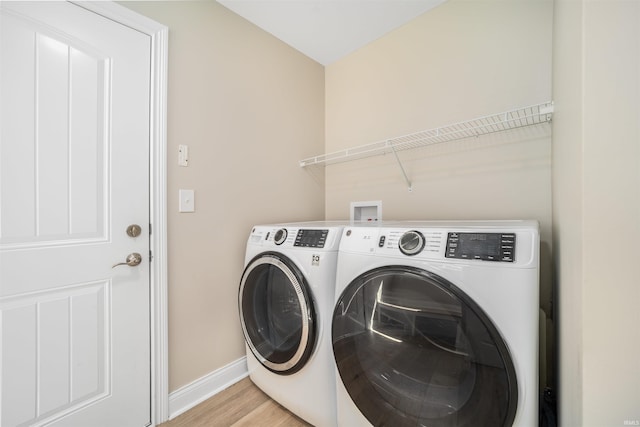 laundry room with light hardwood / wood-style floors and washing machine and clothes dryer