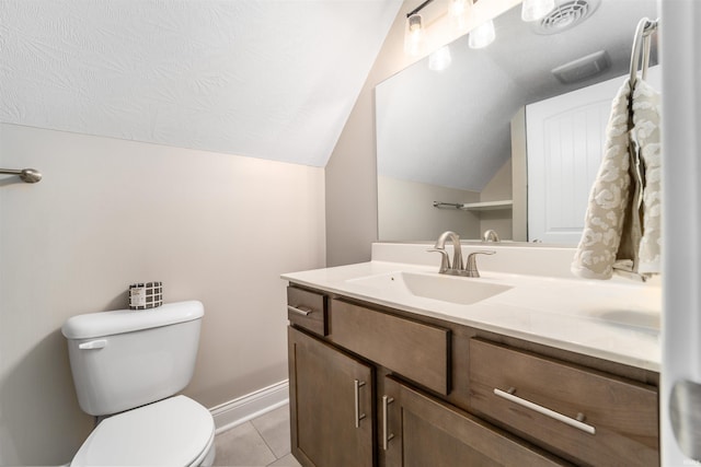 bathroom featuring vanity, lofted ceiling, tile patterned floors, and toilet