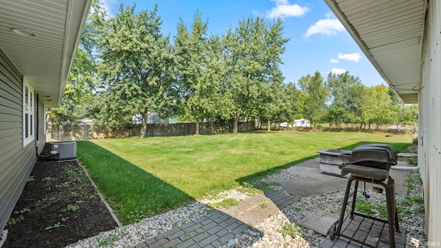 view of yard with central AC unit and a patio