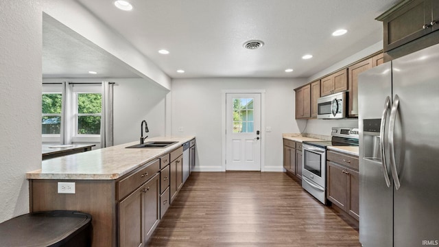 kitchen with stainless steel appliances, sink, and dark wood-type flooring