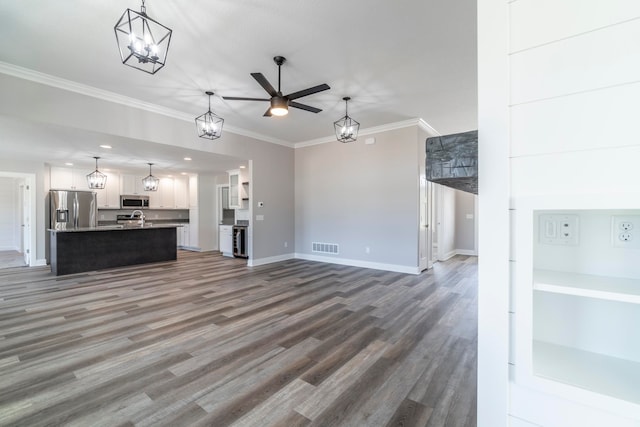 unfurnished living room featuring crown molding, sink, dark hardwood / wood-style floors, and ceiling fan with notable chandelier