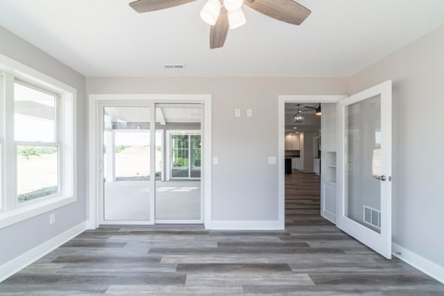 empty room featuring dark wood-type flooring and ceiling fan