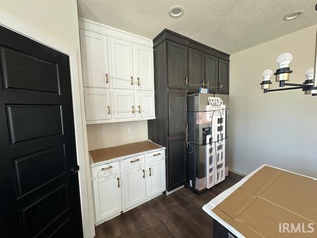 kitchen with dark wood-type flooring, recessed lighting, white cabinetry, and a textured ceiling