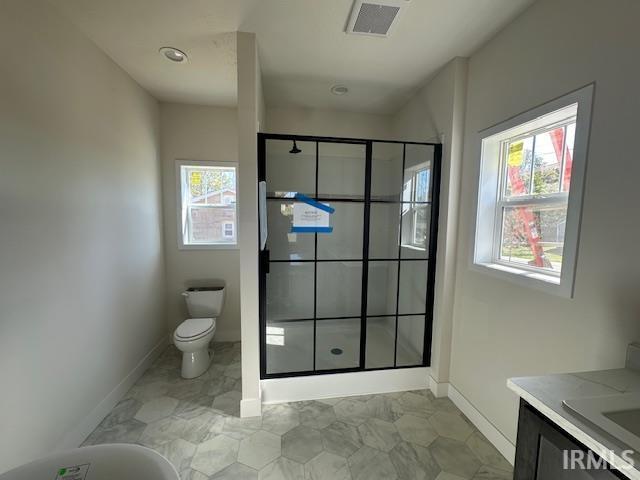 bathroom featuring visible vents, toilet, a stall shower, vanity, and baseboards