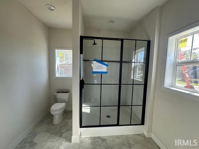 full bathroom featuring baseboards, plenty of natural light, a shower stall, and toilet