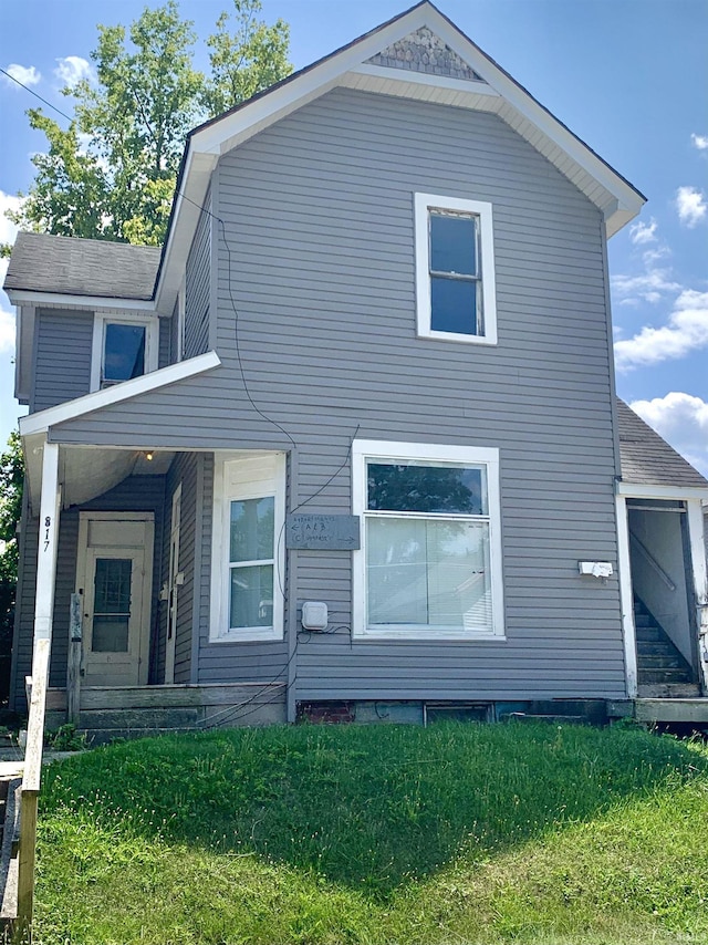 rear view of property with a lawn