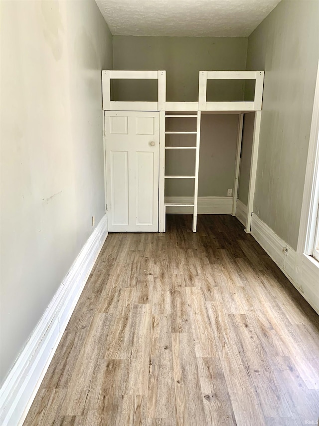 unfurnished bedroom featuring light hardwood / wood-style flooring and a textured ceiling