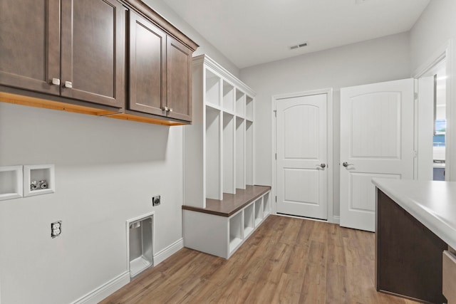 clothes washing area with hookup for a washing machine, cabinets, light wood-type flooring, and hookup for an electric dryer