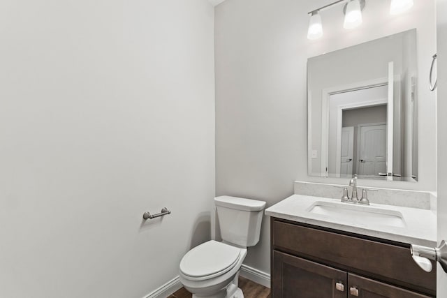 bathroom featuring vanity, toilet, and hardwood / wood-style flooring