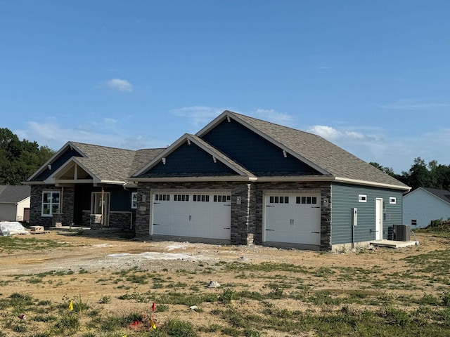 craftsman-style house featuring cooling unit and a garage