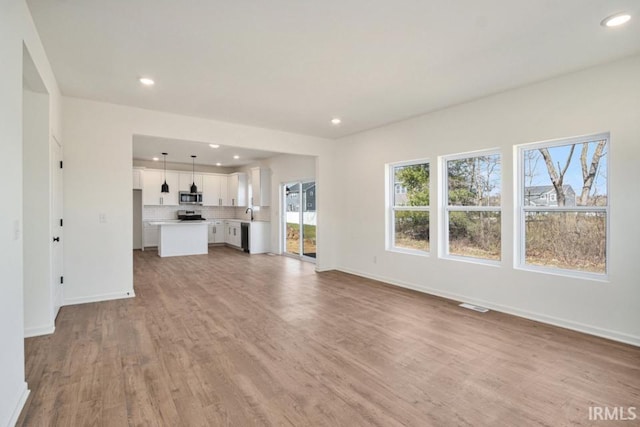 unfurnished living room with light hardwood / wood-style flooring