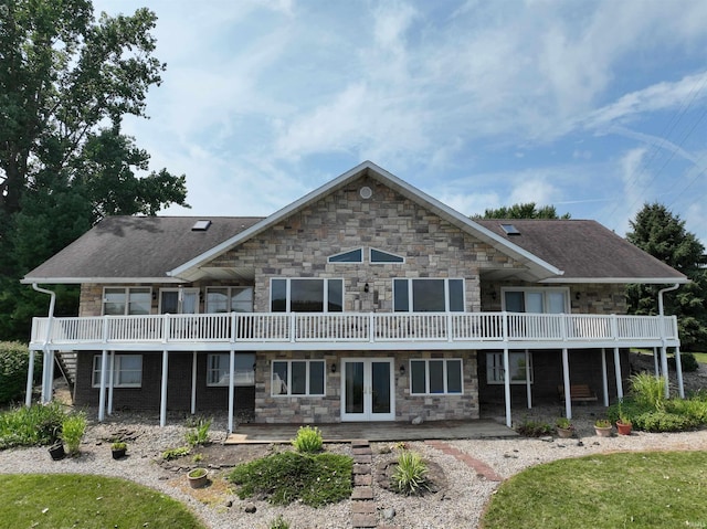 rear view of house with a patio, a balcony, and french doors