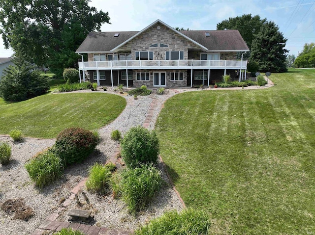 rear view of house featuring stone siding and a yard