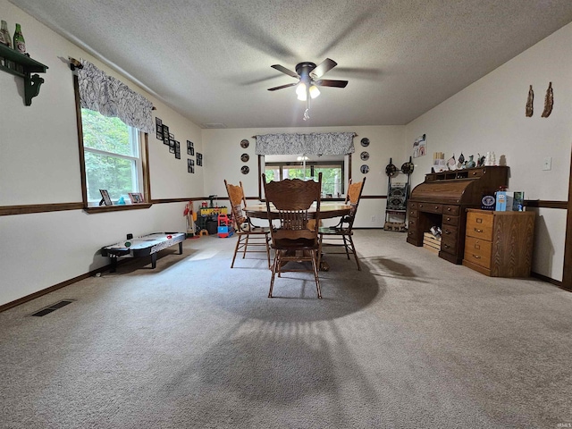 dining room with ceiling fan, a textured ceiling, and carpet