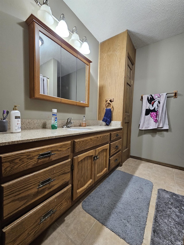 bathroom with vanity, tile patterned flooring, and a textured ceiling