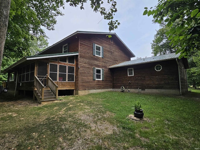 back of house featuring a lawn and a sunroom