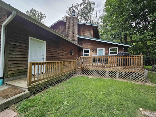 rear view of property with a yard and a deck