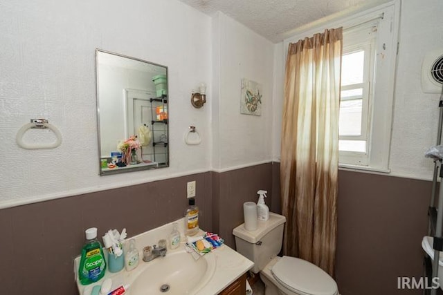 bathroom featuring vanity, a textured ceiling, and toilet