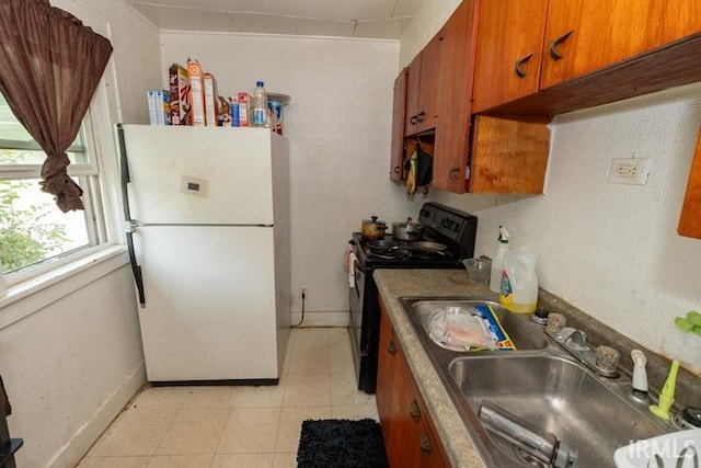 kitchen featuring sink, black range with electric stovetop, white refrigerator, and light tile patterned flooring