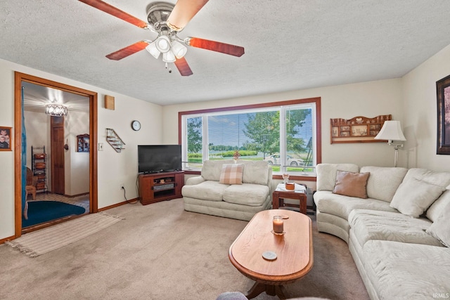 living room with ceiling fan, light carpet, and a textured ceiling