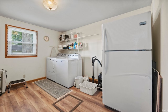 laundry room with separate washer and dryer and light hardwood / wood-style flooring