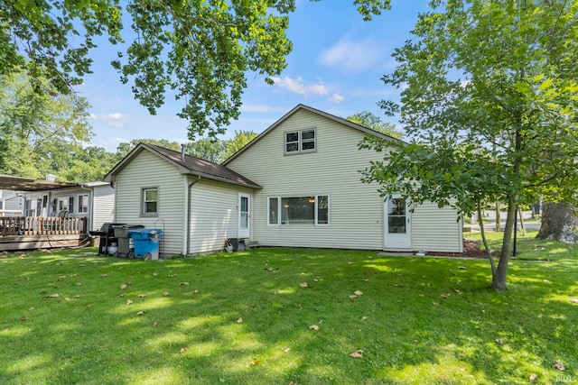 rear view of property with a yard and a deck