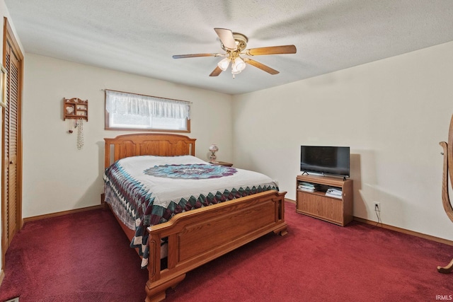 bedroom with ceiling fan, a textured ceiling, dark carpet, and a closet