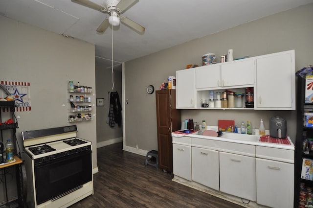 kitchen with sink, white cabinets, ceiling fan, dark wood-type flooring, and gas range oven