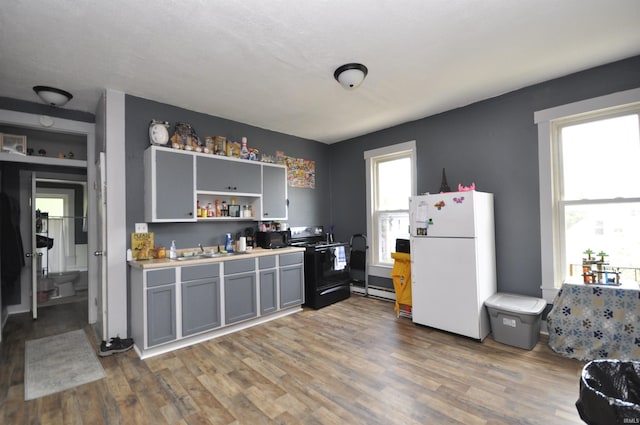 kitchen featuring gray cabinetry, a wealth of natural light, white fridge, and range with electric stovetop