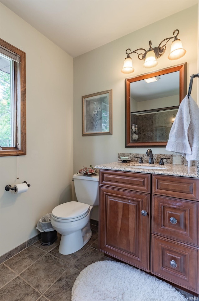 bathroom with tile patterned flooring, vanity, a shower, and toilet