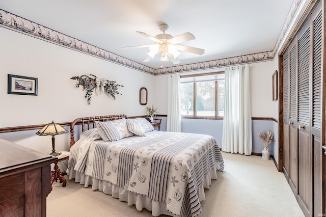 bedroom with ceiling fan, a closet, and light carpet