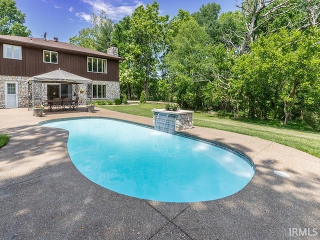 view of swimming pool with a gazebo, pool water feature, a yard, and a patio