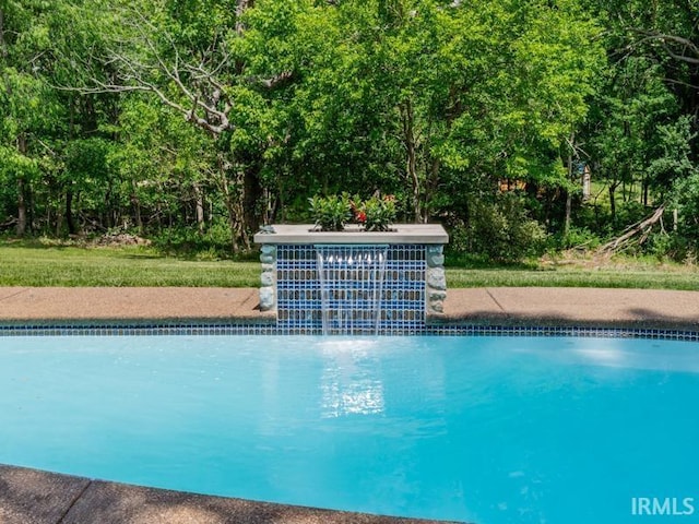 view of swimming pool with pool water feature