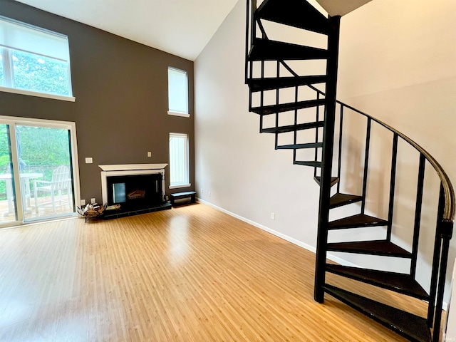 stairway with hardwood / wood-style floors and a high ceiling