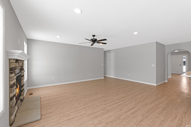 unfurnished living room featuring ceiling fan, light hardwood / wood-style floors, and a fireplace