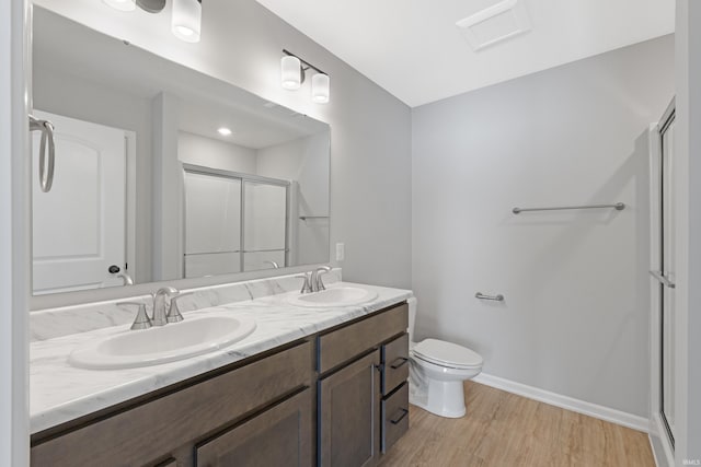 bathroom featuring toilet, vanity, walk in shower, and hardwood / wood-style floors