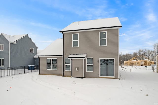 view of snow covered back of property