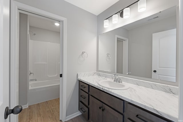 bathroom featuring  shower combination, vanity, and hardwood / wood-style flooring