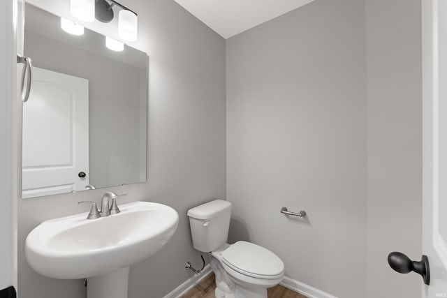 bathroom featuring sink, hardwood / wood-style flooring, and toilet