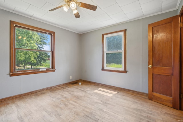 spare room featuring crown molding, visible vents, light wood-style flooring, ceiling fan, and baseboards