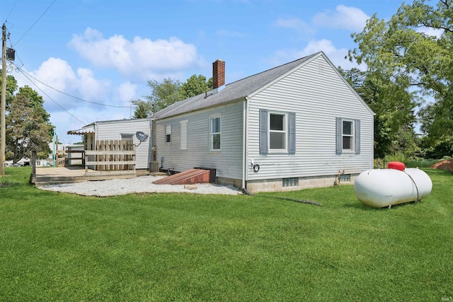 rear view of property featuring a yard, a chimney, and a wooden deck