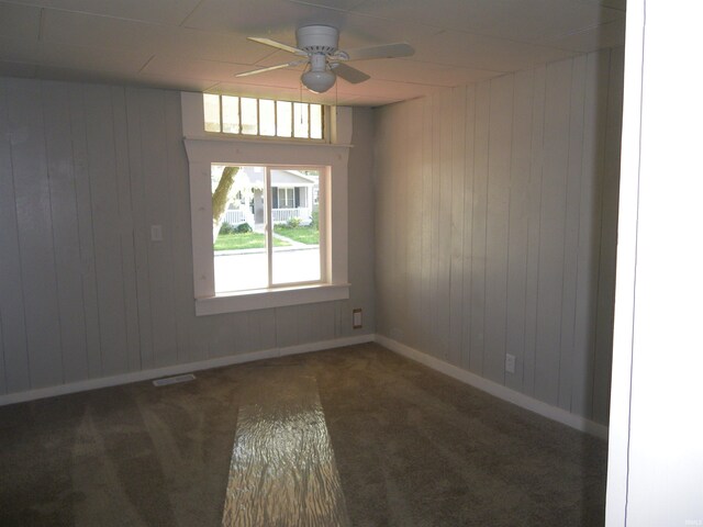 carpeted spare room with ceiling fan