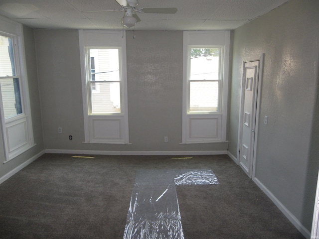 carpeted spare room with a paneled ceiling and ceiling fan