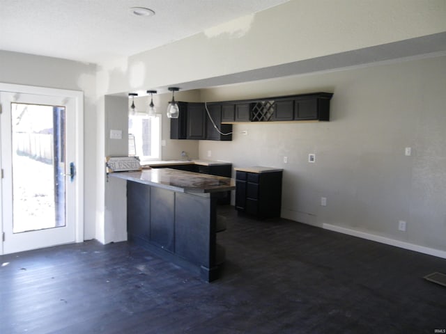 kitchen featuring dark hardwood / wood-style flooring, a kitchen breakfast bar, and kitchen peninsula